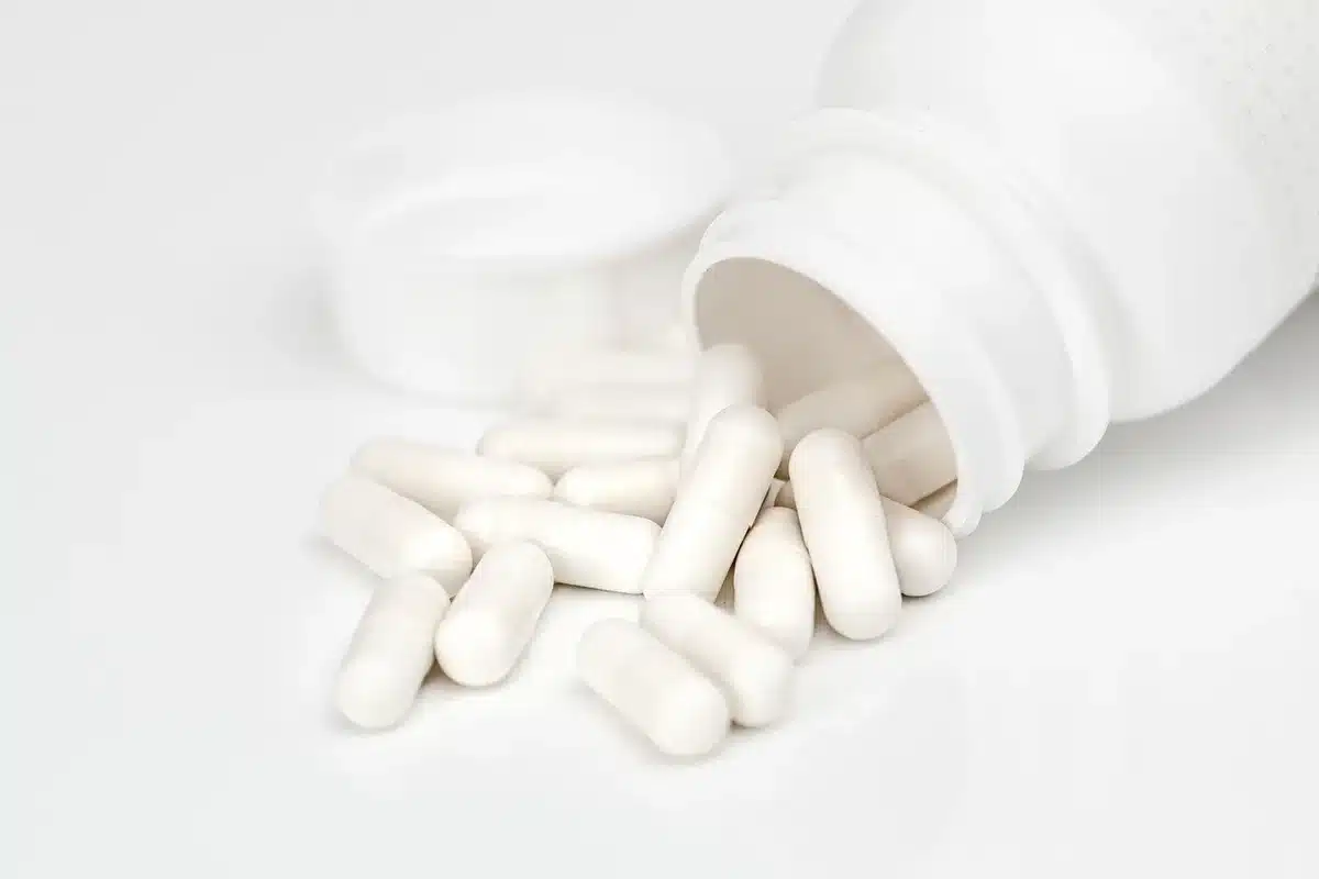 Apotheker berät einen Patienten an der Apothekentheke mit Medikamentenregalen im Hintergrund