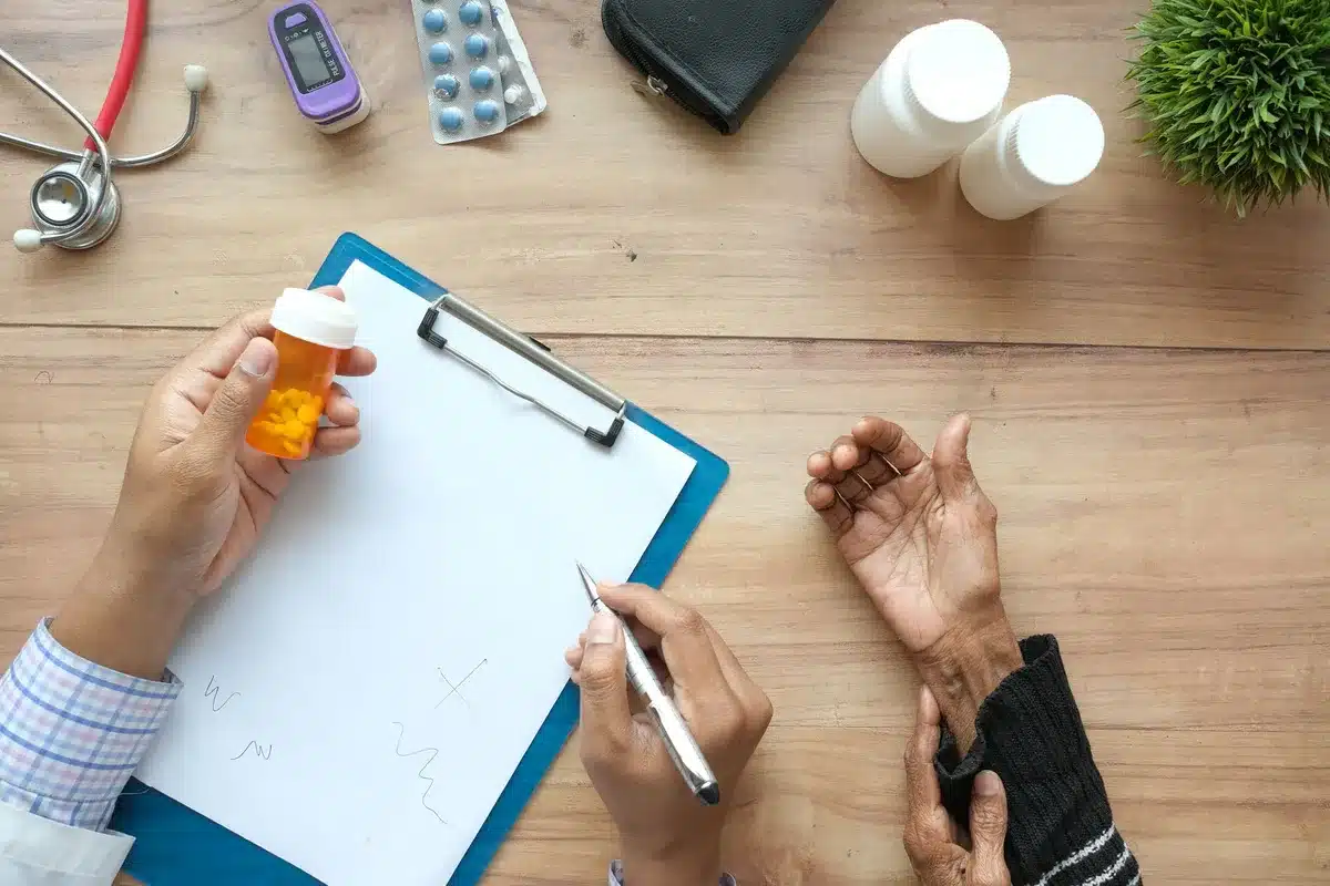 Arztschreibtisch mit Rezeptblock, Medikamentenfläschchen und Patientenakte