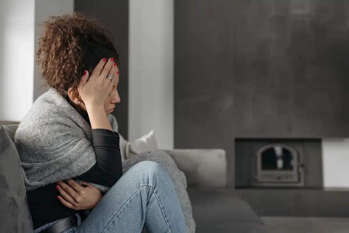 Erschöpfte Frau, die typische Symptome einer Schilddrüsenunterfunktion zeigt