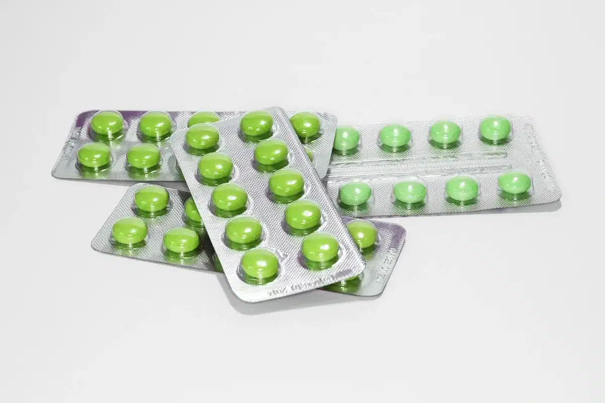 Apotheker liest Packungsbeilage neben Medikamentenverpackung bei Tageslicht