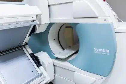 Patient sitzt nervös beim Arzt, Hände verschränkt, Blick gesenkt, während der Arzt aufmerksam zuhört