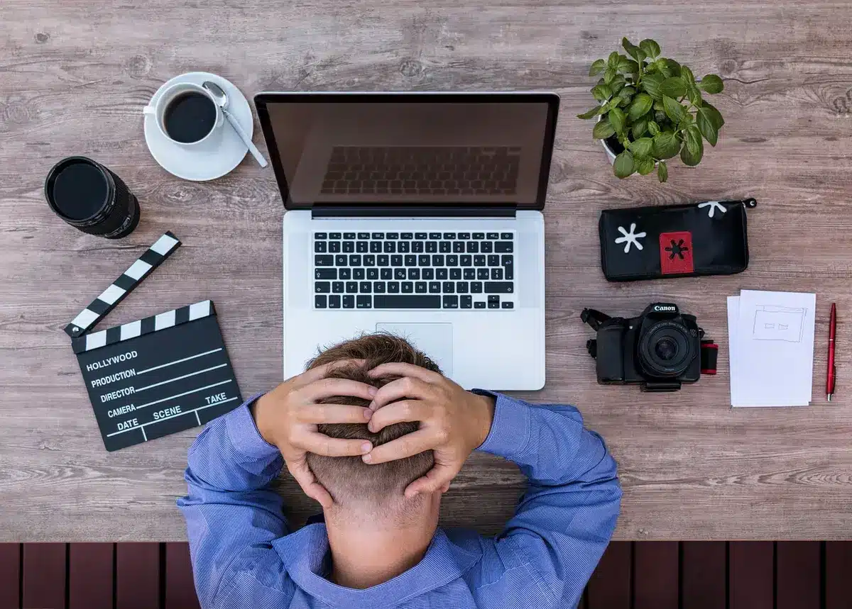 Tageshelles Büro mit Lebensläufen, Laptop und Händen, die Papiere sortieren