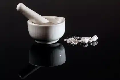 Apotheker an Schreibtisch mit Rezept, Zahlungsterminal und Medikamentenboxen
